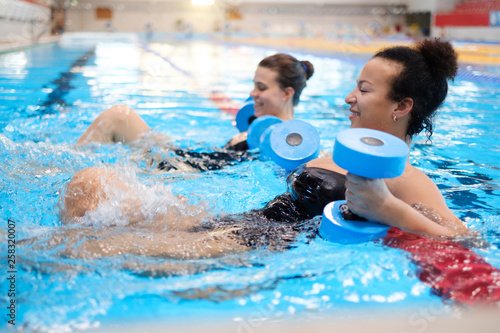 Multiracial couple attending water aerobics class in a swimming pool © Nejron Photo