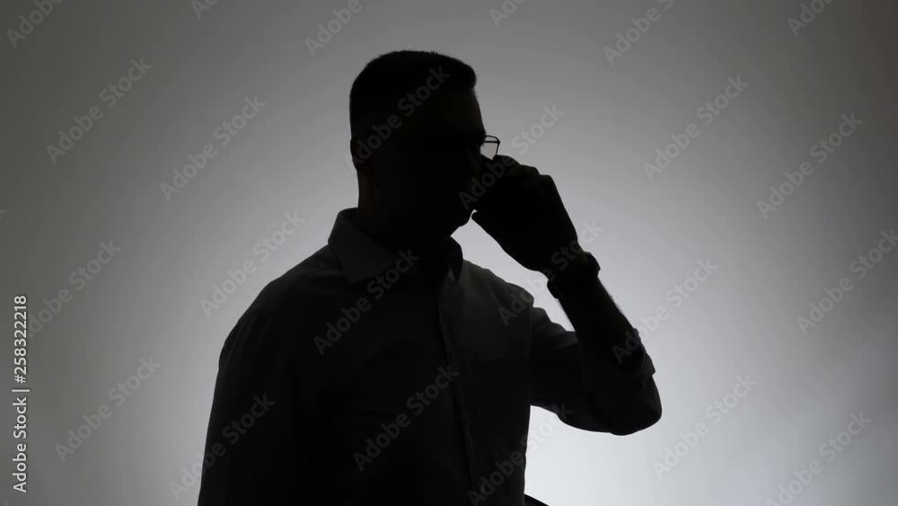 Silhouette of a man on a white background. Portrait of a businessman silhouette talking on the phone Silhouette of a man on a white background. Portrait of a businessman silhouette talking on the phone