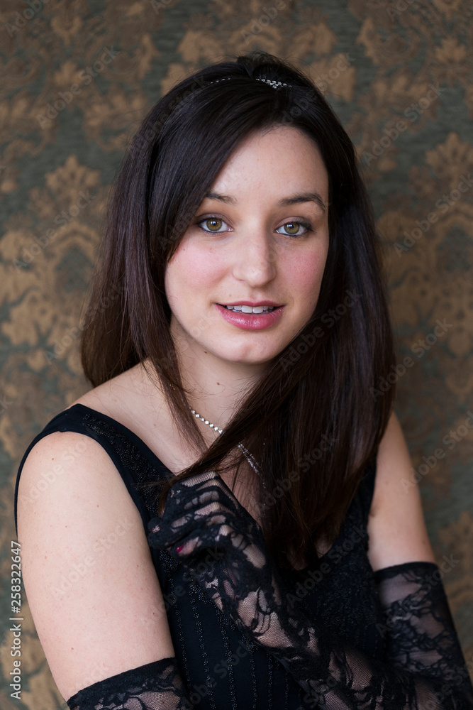 Medium vertical portrait of gorgeous smiling brunette young woman in sleeveless dress wearing high lace gloves, sparkling headband and necklace Medium vertical portrait of gorgeous smiling brunette young woman in sleeveless dress wearing high lace gloves, sparkling headband and necklace
