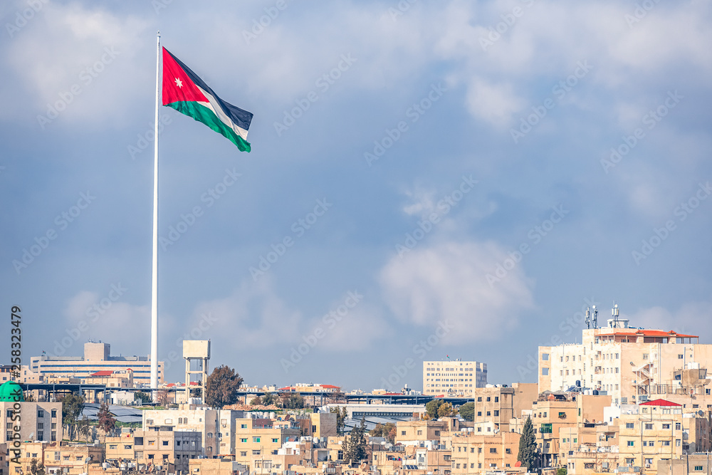 02/18/2019 Amman, Jordan, the flag of Jordan on the background of the gloomy sky walks in the wind above the capitals of the capital of the Middle Eastern state