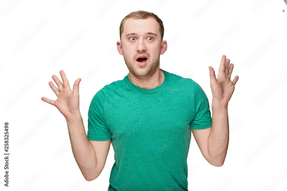 A funny young man in a green shirt shows hands up A funny young man in a green shirt shows hands up