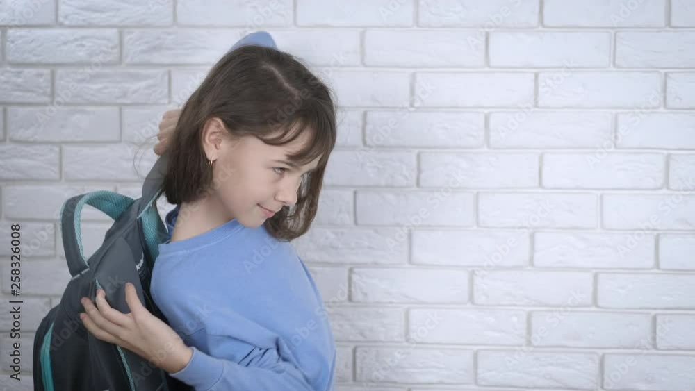 The child puts on a backpack. The child puts on a backpack.