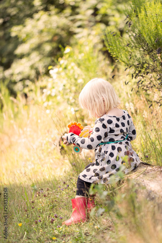 little girl with wooden chicken in park