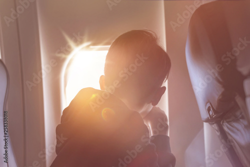 A boy have flight looking in the airplane window or porthole. photo