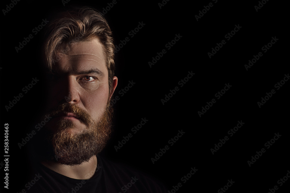 Close-up portrait strong serious brutal bearded man on black. Confident and dramatic concept Close-up portrait strong serious brutal bearded man on black. Confident and dramatic concept