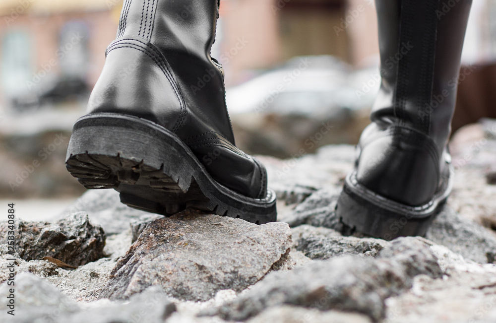 Close up view sole black leather boot on stone nature background outdoor Close up view sole black leather boot on stone nature background outdoor