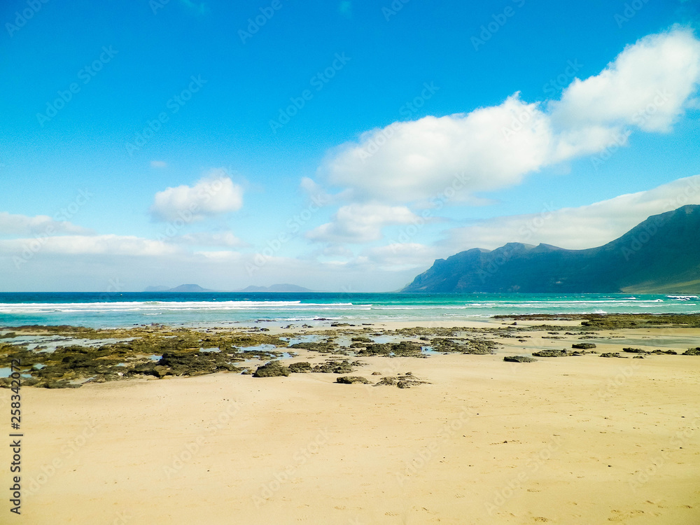 Beach and mountains - beautiful coast in Caleta de Famara, Lanzarote Canary Islands. Beach and mountains - beautiful coast in Caleta de Famara, Lanzarote Canary Islands.