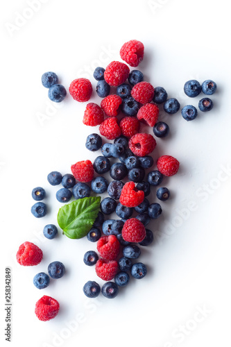 Raspberries and blueberries isolated on white background with copy space