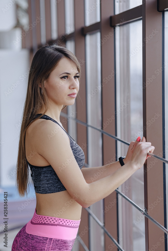 young girl wearing sportswear in a gym near the window