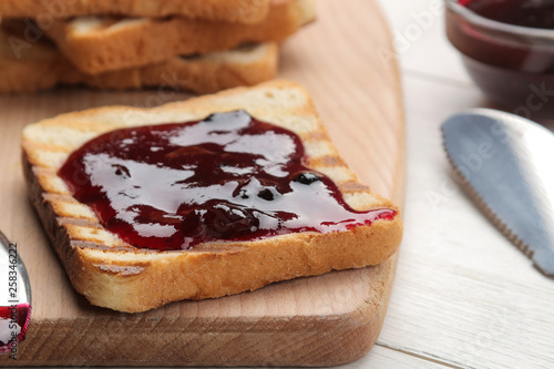 toasts with jam. fried crispy toasts with red jam on a white wooden table. breakfast. close-up