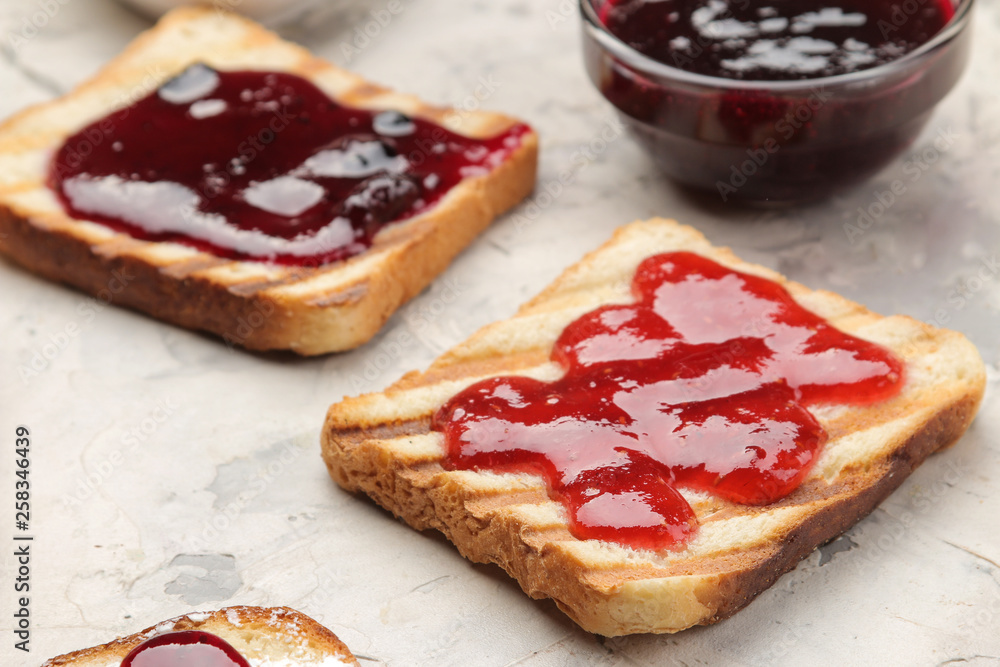 toasts with jam. fried crispy toasts with red jam on a light concrete table. breakfast. close-up toasts with jam. fried crispy toasts with red jam on a light concrete table. breakfast. close-up