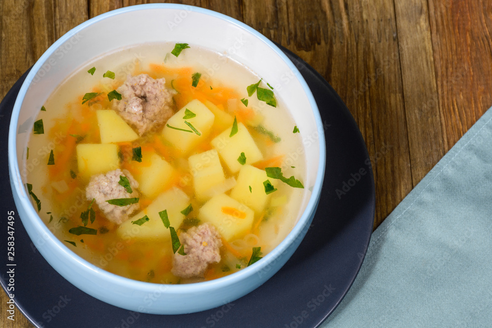 Vegetable soup with chicken cutlets and pieaces of homemade bread.Side view with copy space. Vegetable soup with chicken cutlets and pieaces of homemade bread.Side view with copy space.