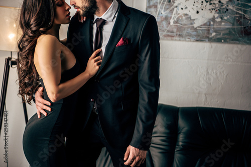 Εκτύπωση καμβά cropped view of man in suit standing with woman in black dress