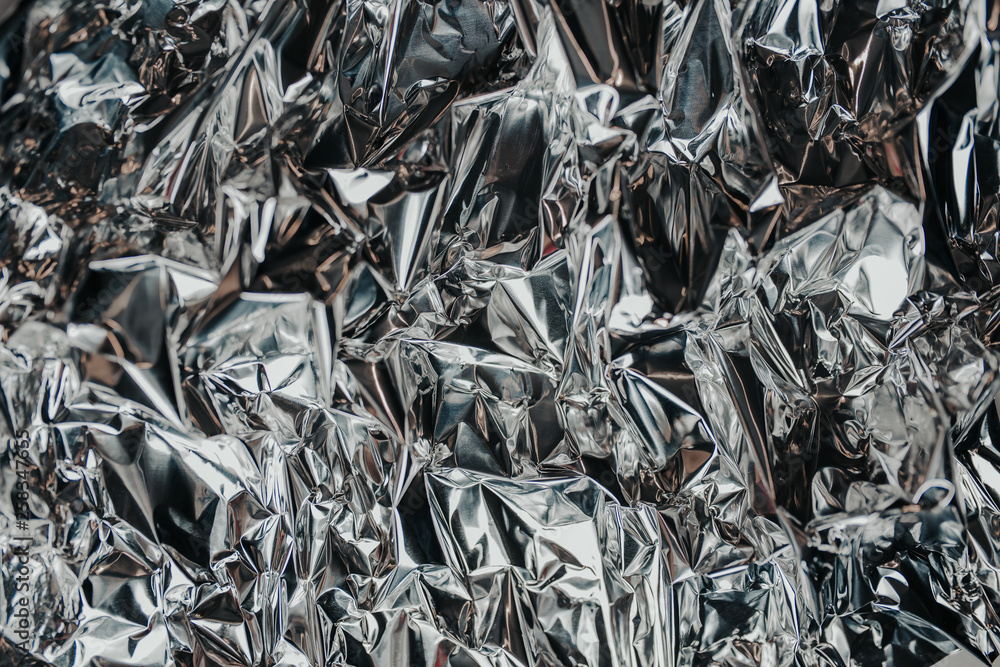 Silver rumpled foil. Gray background with texture Silver rumpled foil. Gray background with texture