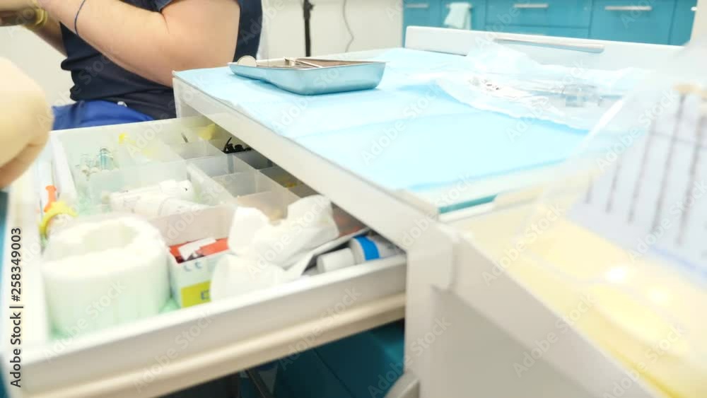 People and oral hygiene with doctor at work as dentist in clinic, opening drawer and showing tools in dental clinic. Dental Technician Places Sterile Tools in Drawer. 4k People and oral hygiene with doctor at work as dentist in clinic, opening drawer and showing tools in dental clinic. Dental Technician Places Sterile Tools in Drawer. 4k
