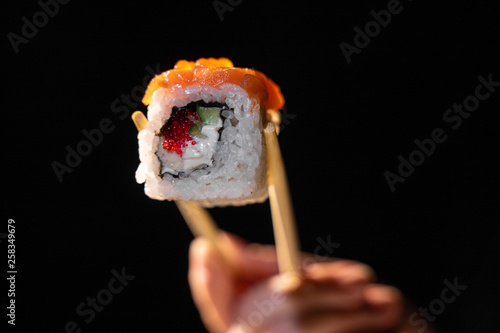 traditional fresh japanese sushi rolls on a black background