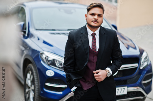 Rich indian businessman in formal wear standing against business suv car. © AS Photo Family