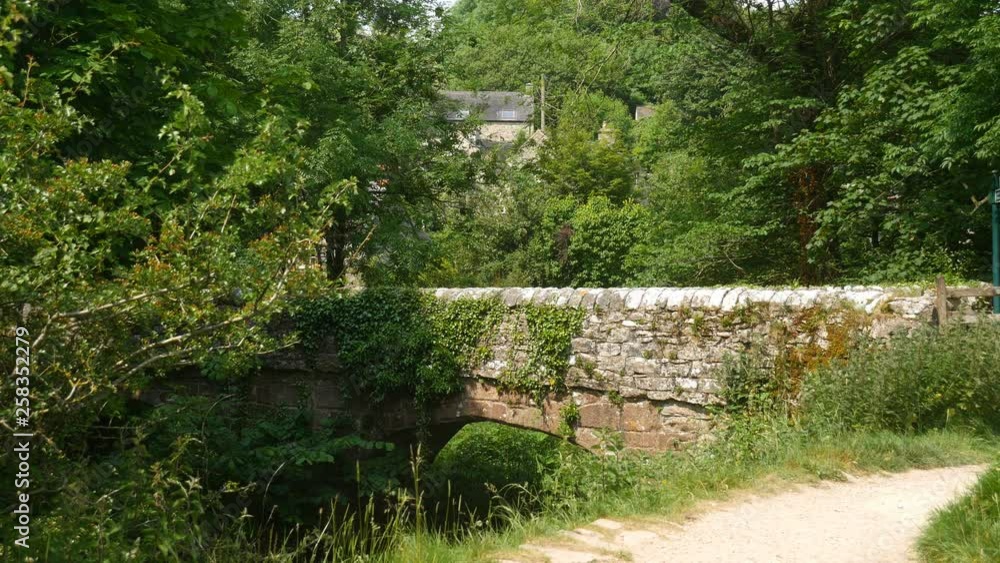 Ancient stone bridge and the Milldale village, Peak District, England. Ancient stone bridge and the Milldale village, Peak District, England.