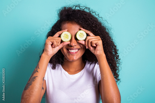 Wallpaper Mural Fun portrait of beautiful black african model holding a cucumber slice to her eye, rejuvenating skin care regime treatment facial beauty concept Torontodigital.ca