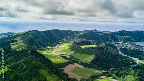 Fototapeta Naklejka Na Ścianę i Meble -  Aerial view on scenic landscape of volcano and green fields around it. Special shape of ground. Top view from drone. Azores islands, Sao Miguel, Portugal.