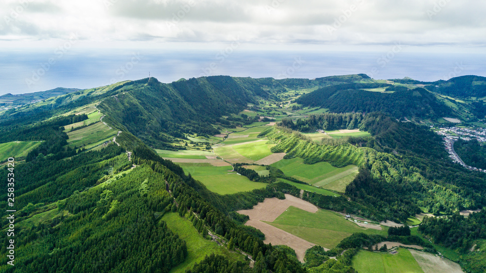 Aerial view on scenic landscape of volcano and green fields around it. Special shape of ground. Top view from drone. Azores islands, Sao Miguel, Portugal.