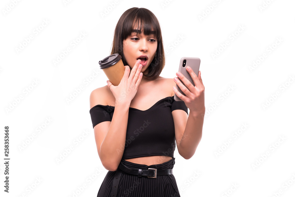 Young beautiful woman with smart phone with coffee cup isolated on white background Young beautiful woman with smart phone with coffee cup isolated on white background