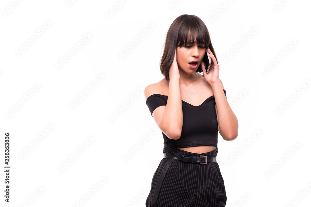 Portrait of a shocked young woman dressed in black dress looking at mobile phone isolated over white background Portrait of a shocked young woman dressed in black dress looking at mobile phone isolated over white background
