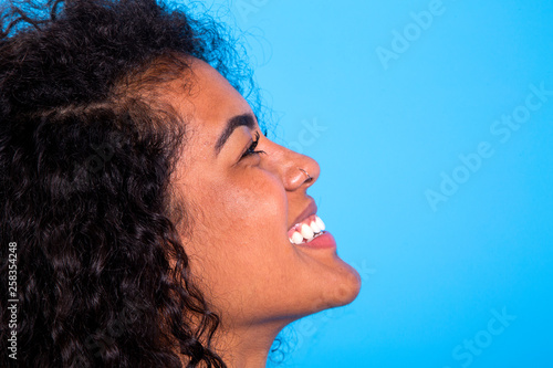 side view of pretty african woman beauty on blue background - Imagem