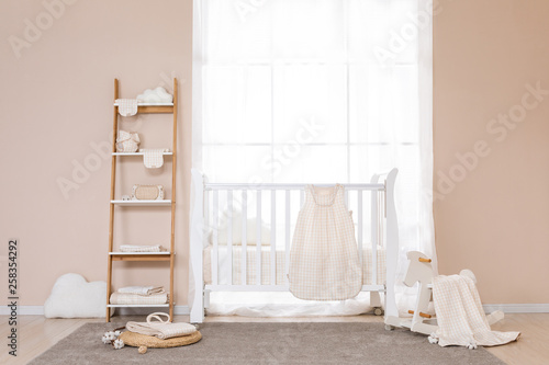 Shot of a crib in a modern white nursery room