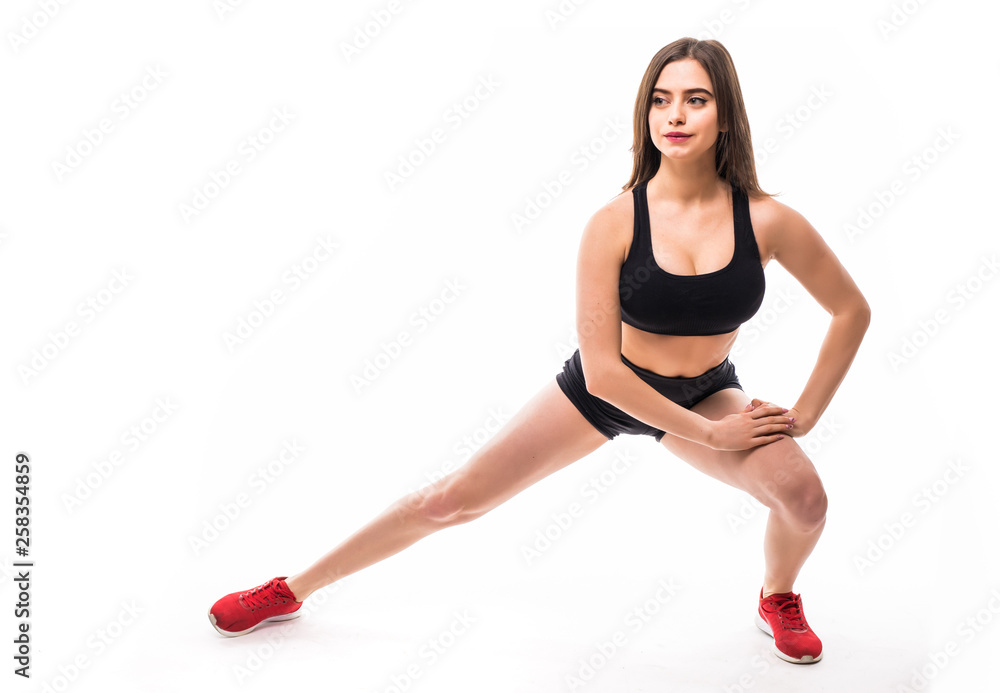 Fitness woman doing stretching workout. Full length shot of young woman on white background. Stretching and motivation Fitness woman doing stretching workout. Full length shot of young woman on white background. Stretching and motivation