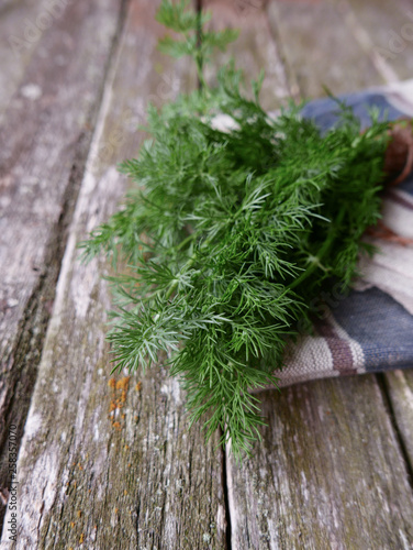 bundle of dill on a wooden background and linen napking