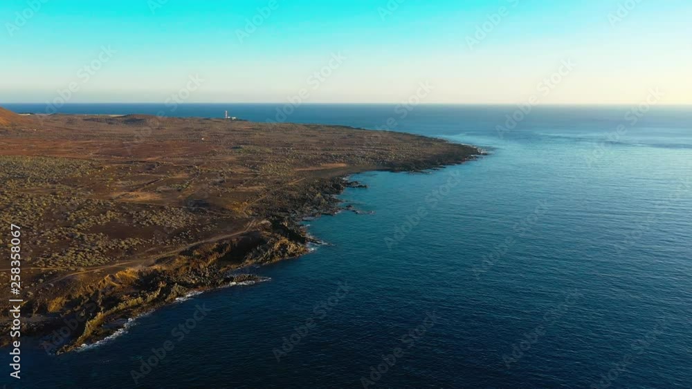 Drone flying along the coastline of Palm de Mar during sunset, showing the sea and the dry land. Drone flying along the coastline of Palm de Mar during sunset, showing the sea and the dry land.