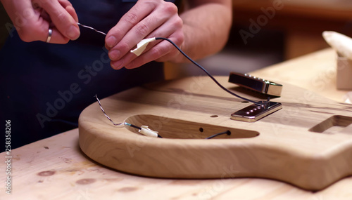 Fotografie Installing electrical parts inside a handmade guitar