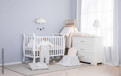 Shot of a crib in a modern white nursery room