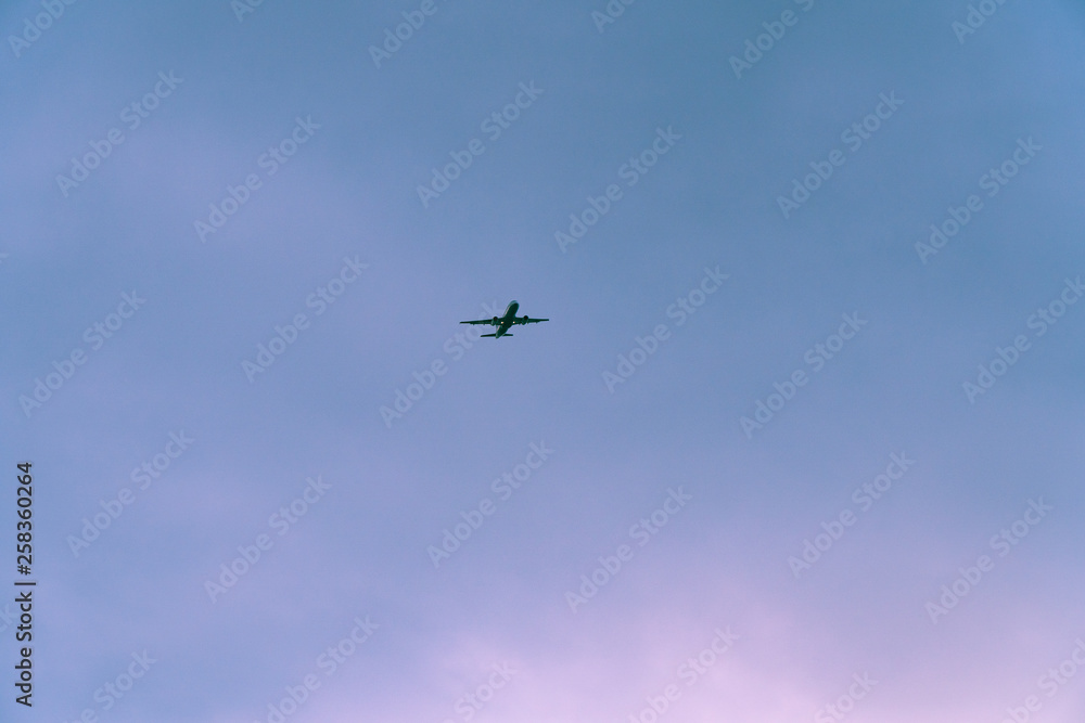 Airplane is flying in the sky of thessaloniki.The sky is almost clear and the time of day is after sunset
