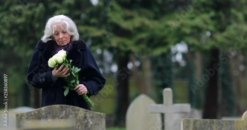 Untitled Project 1Sad Senior Woman With Flowers Standing By Grave