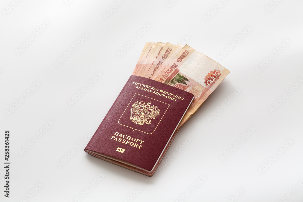 Russian passport and a pack of five thousandth ruble banknotes. Foreign passport in the red cover and Russian money. Concept of travel, wealth, independence. Russian passport and a pack of five thousandth ruble banknotes. Foreign passport in the red cover and Russian money. Concept of travel, wealth, independence.