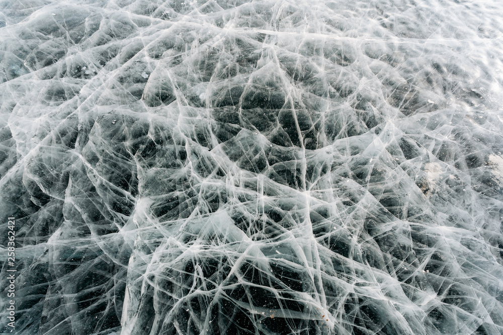 Texture of frozen ice with cracks, frozen like a cobweb. Baikal, Russia Texture of frozen ice with cracks, frozen like a cobweb. Baikal, Russia