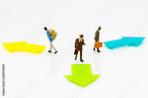 Miniature people standing whit arrow pathway choice. Concepts of problem solving, challenge and Unexpected solutions.