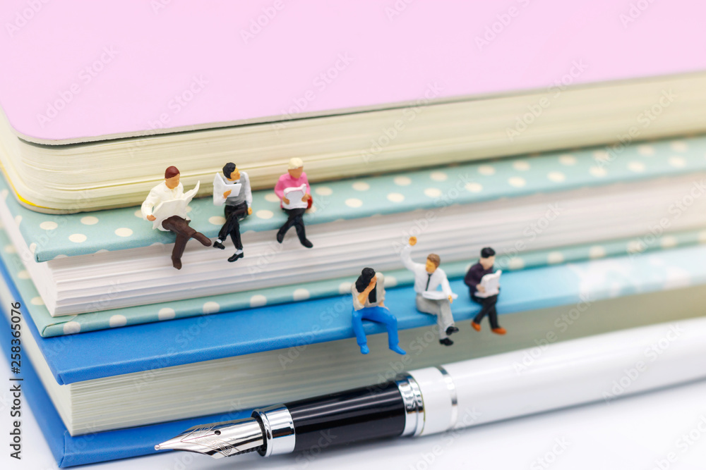Obraz premium Miniature people: Business team reading book, education or business concept.