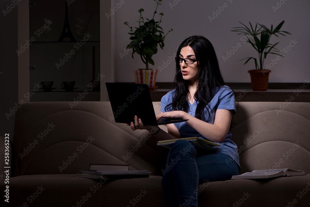 Obraz premium Young female student preparing for exams at night time