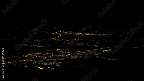 Canvas Print Lights of roads Amsterdam city top view from airplane window at night