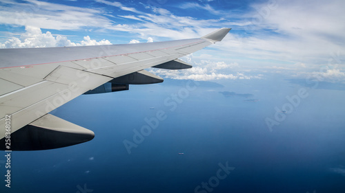 Aerial view of blue ocean from an airplane window. Traveling by air.