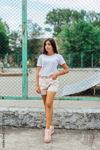 Portrait of a swag girl standing next to rabitz fence