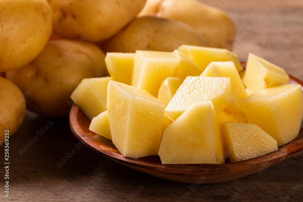 Potatoes and potato sliced on wooden table. Selective focus Potatoes and potato sliced on wooden table. Selective focus