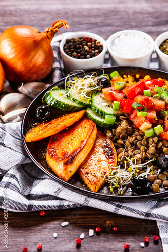 Groats with lentils and vegetables on wooden table