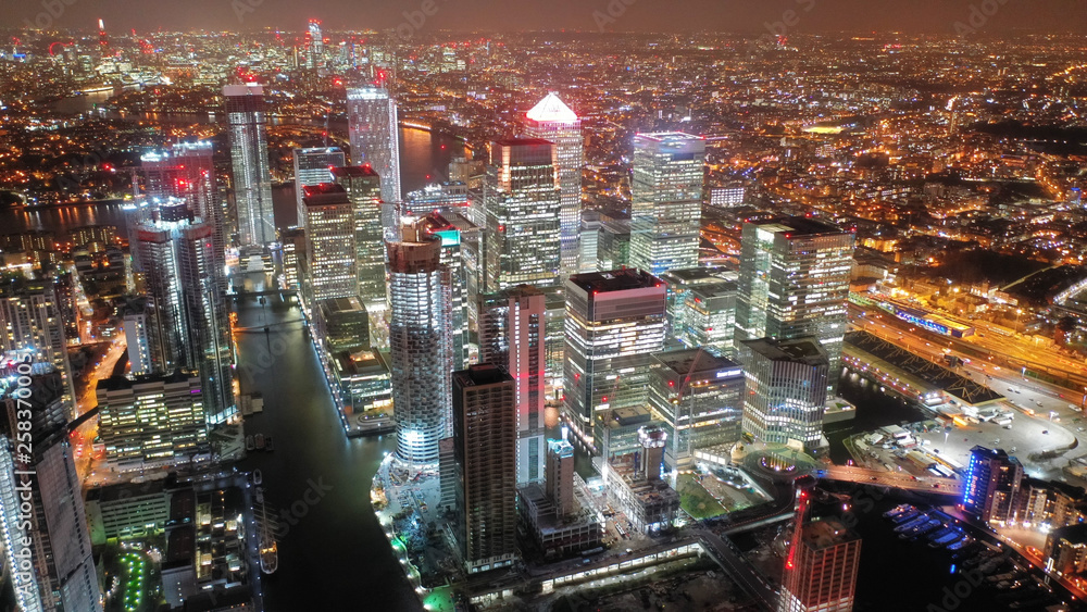 Fototapeta Aerial drone night shot from iconic Canary Wharf skyscrapers business area, Isle of Dogs, London, United Kingdom,
