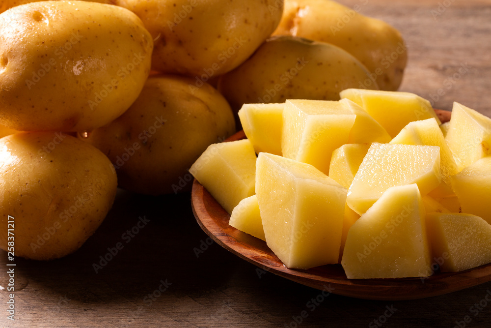 Potatoes and potato sliced on wooden table. Selective focus Potatoes and potato sliced on wooden table. Selective focus