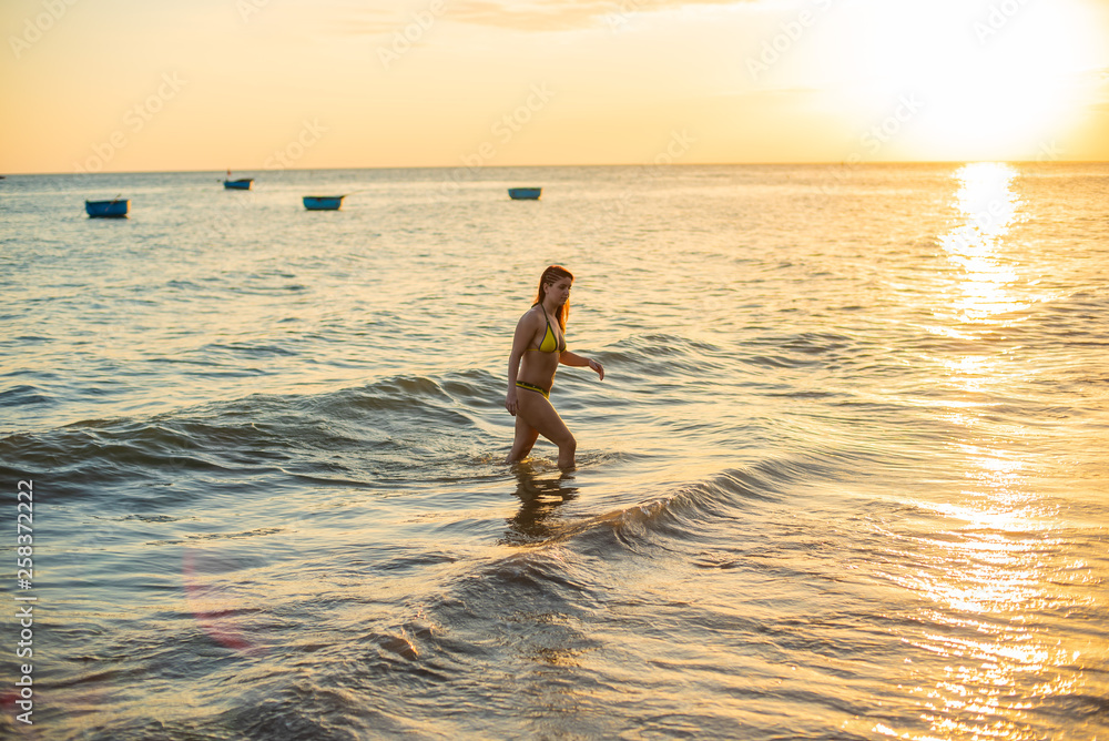 Hot girl in sexy bikini on sunset. Hot young beautiful girl posing in bikini on beach in sunset
