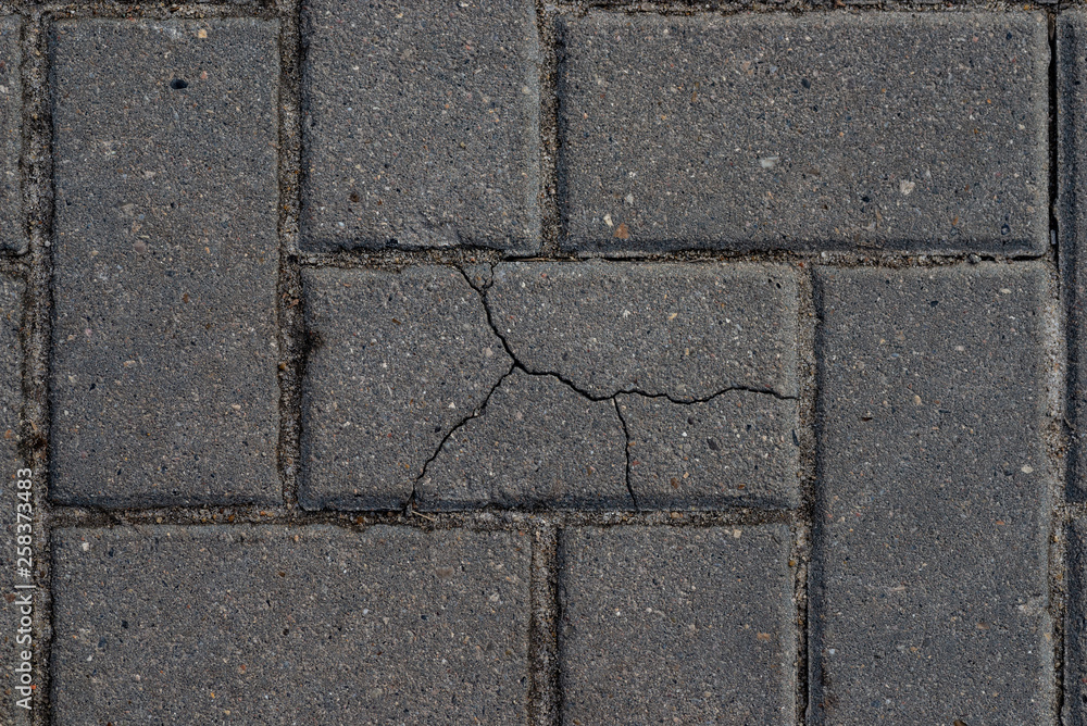 Macro texture of cracked paving slabs. One bad among normal